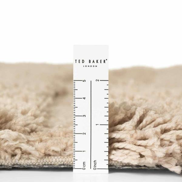 Close-up of a textured fabric with a Ted Baker ruler overlay on a white background