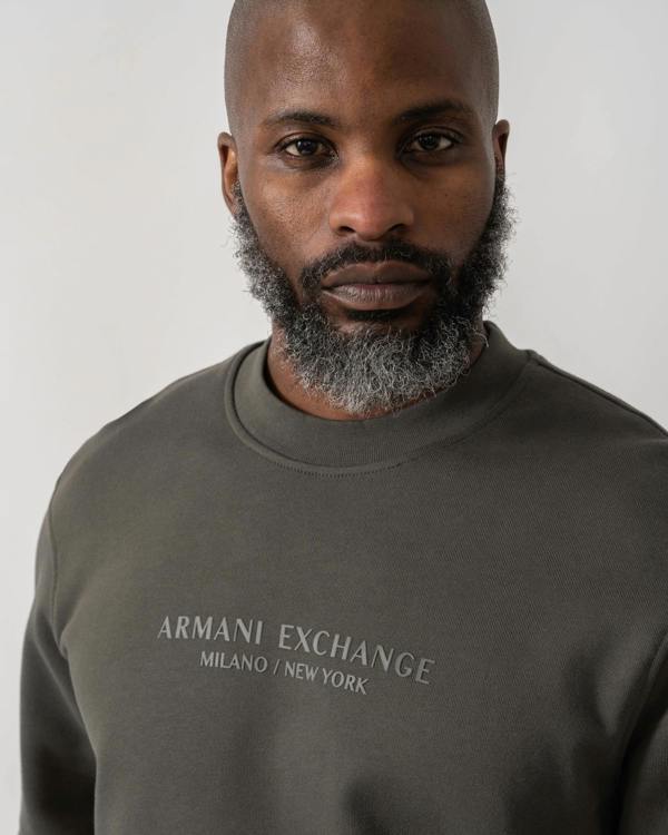Model wearing Armani Exchange Mens Crew Neck Sweatshirt with Tonal Milano/New York Logo in Chimera M8317 - Logo detail
