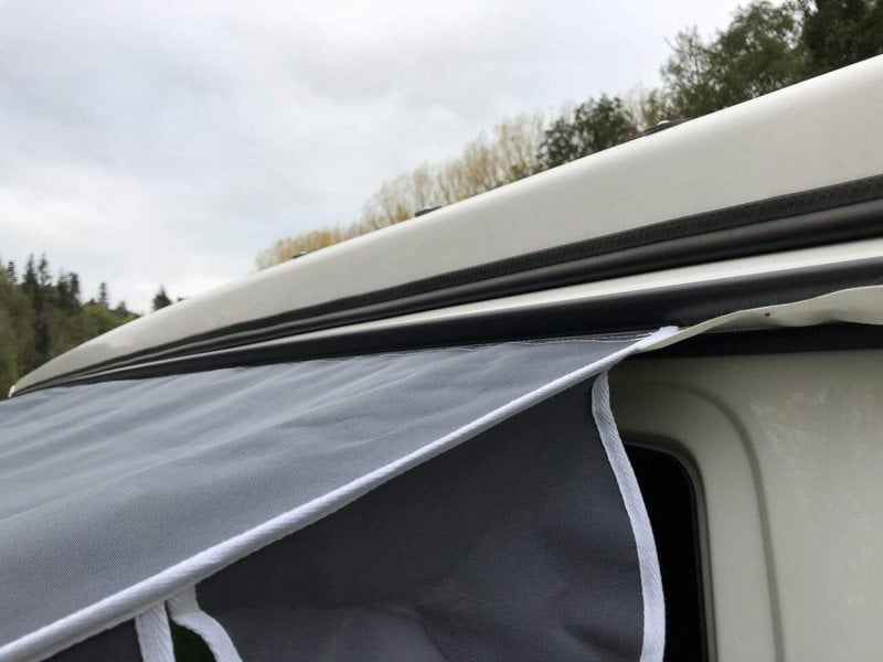 demonstrating how  the Charcoal Shade Campervan Canopy OLPRO attaches to a camper van