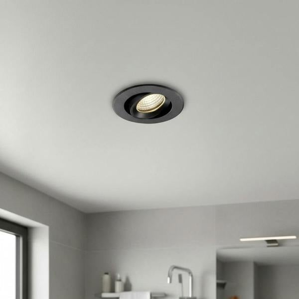 black IP65 LED downlight mounted in the ceiling of a modern bathroom