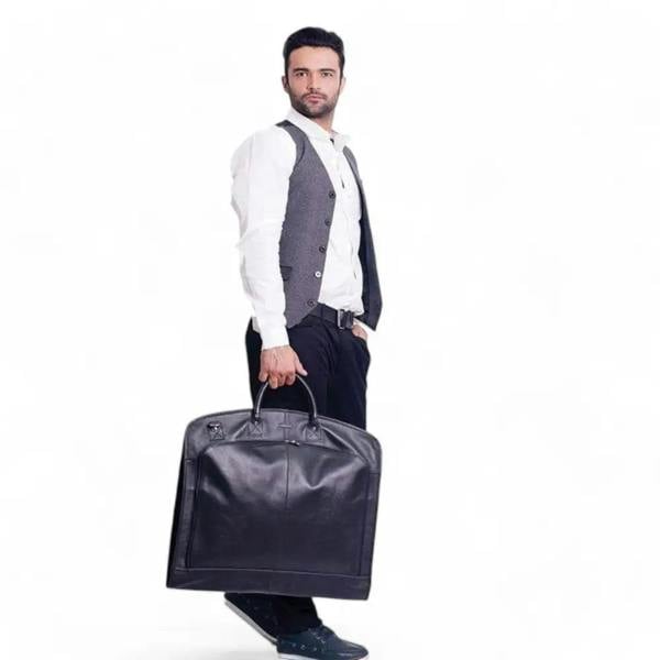 Man holding a large brown garment bag against a white background
