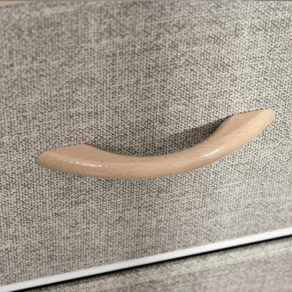 Grey fabric drawer with light wood curved handle on storage dresser cabinet