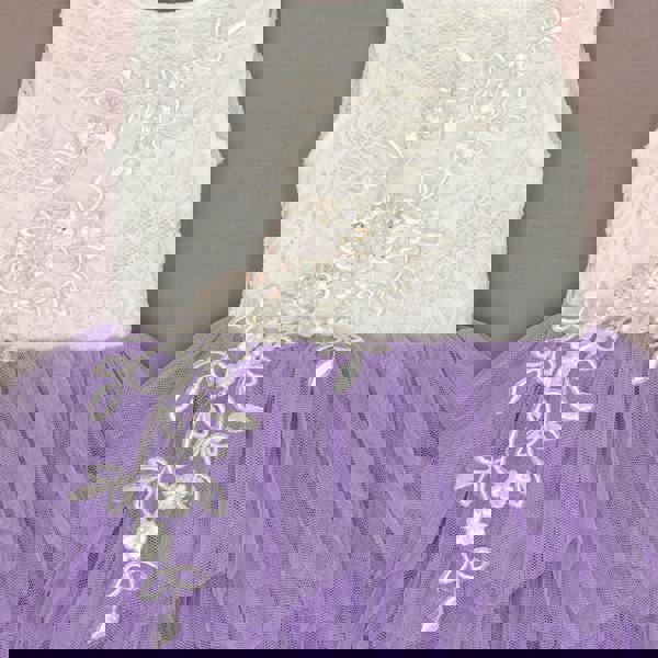 White lace top with floral embellishments and a purple tulle skirt on a neutral background