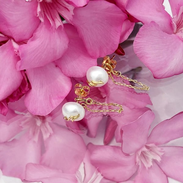 Gold pearl studs with chains looping around lobe by LENAE London.