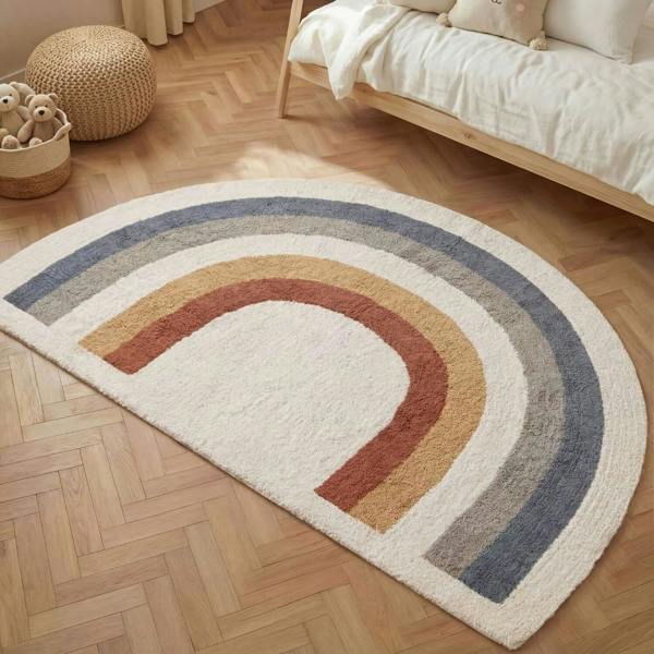 Rainbow-shaped rug on a wooden floor with a bed and toys in the background