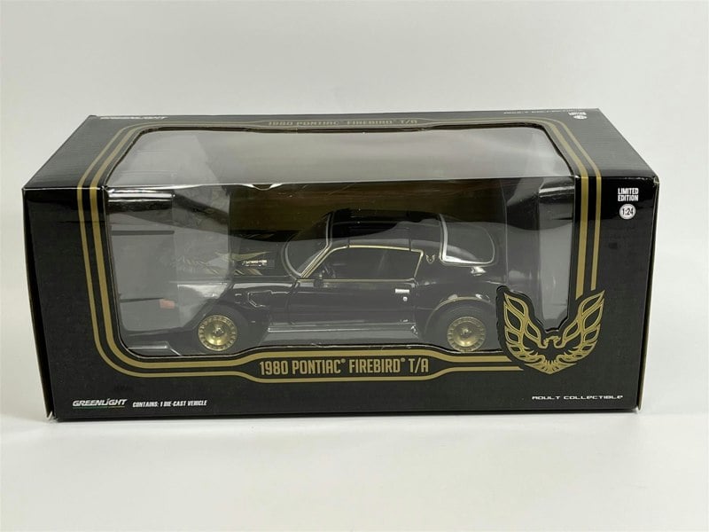 a black and gold toy car in a box