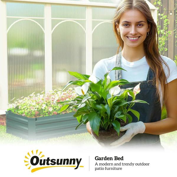 Green galvanized steel raised bed planter with soil and flowering plants, open top.