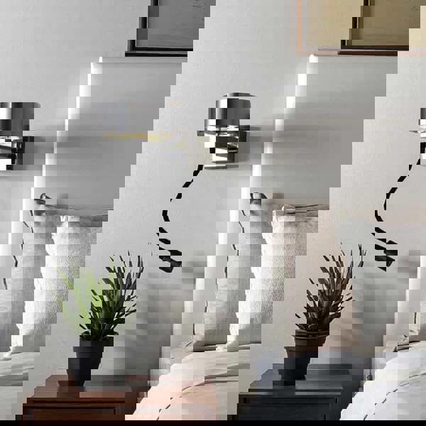 chrome bedside lamp with reading light installed next to the bed in a modern bedroom