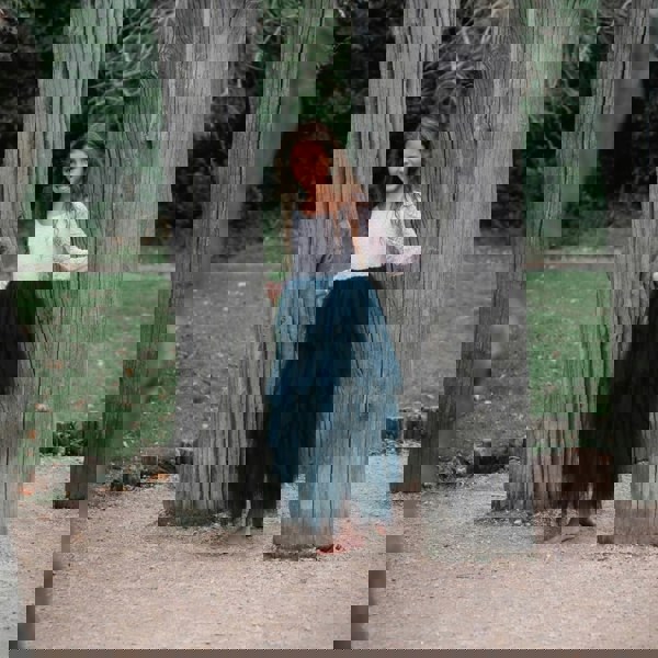 young girl holding to trees
