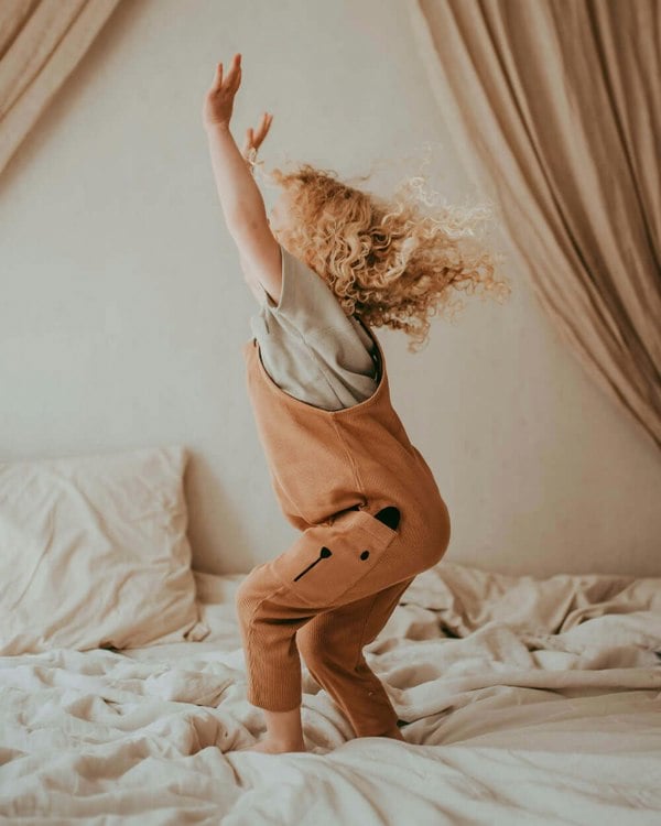 Girl wearing organic cotton gender-neutral kids dungarees