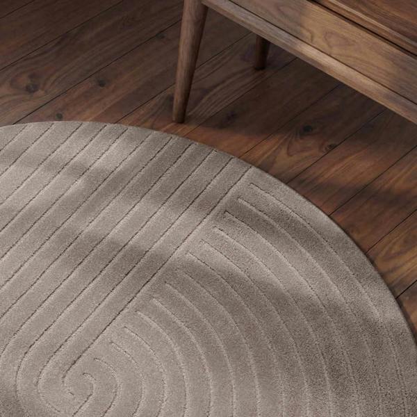 Round beige rug with a textured pattern on a wooden floor