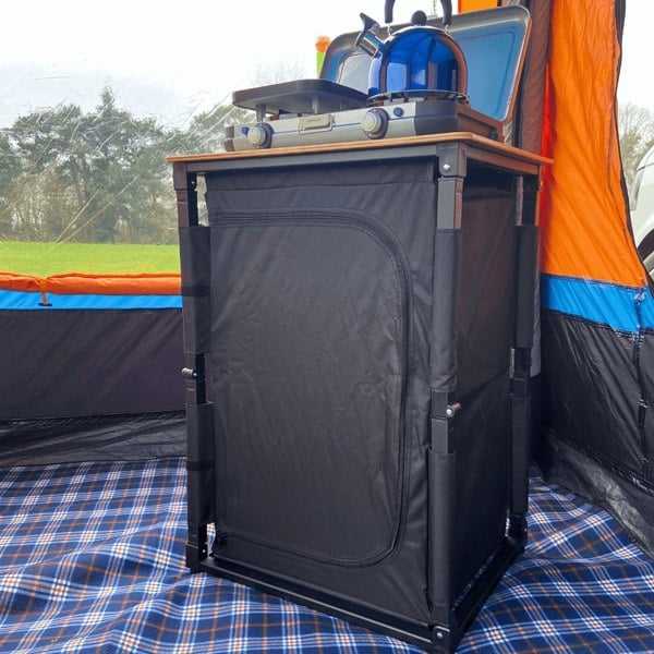 The OLPRO Bamboo Cooking Table with the doors closed in a campervan awning.