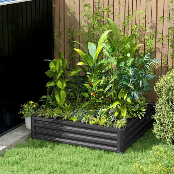 Dark grey raised garden bed with slatted sides, filled with mixed greenery