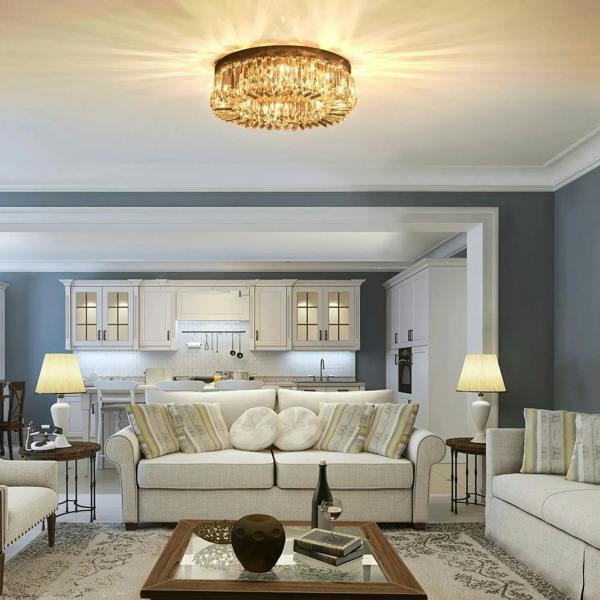 Round silver crystal ceiling light fixture with glowing bulb through prisms