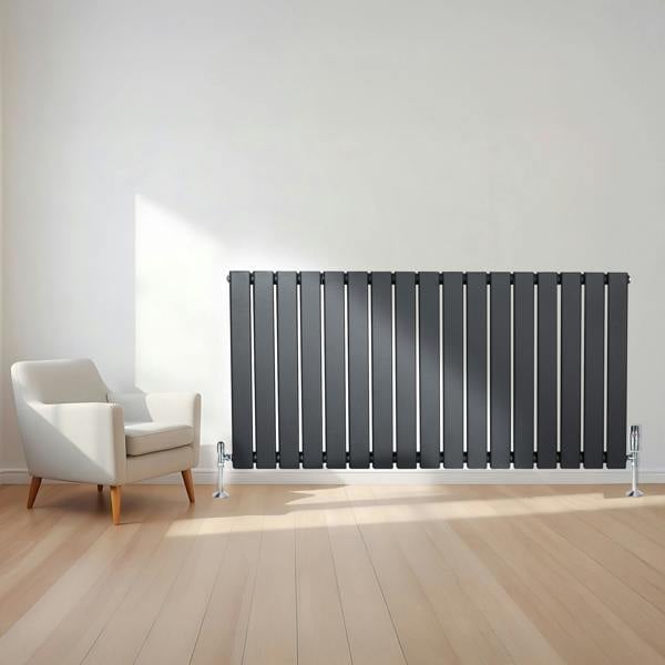 Flat single column radiator in anthracite grey, featuring vertical slats, sleek design, and positioned beside a modern armchair in a bright room