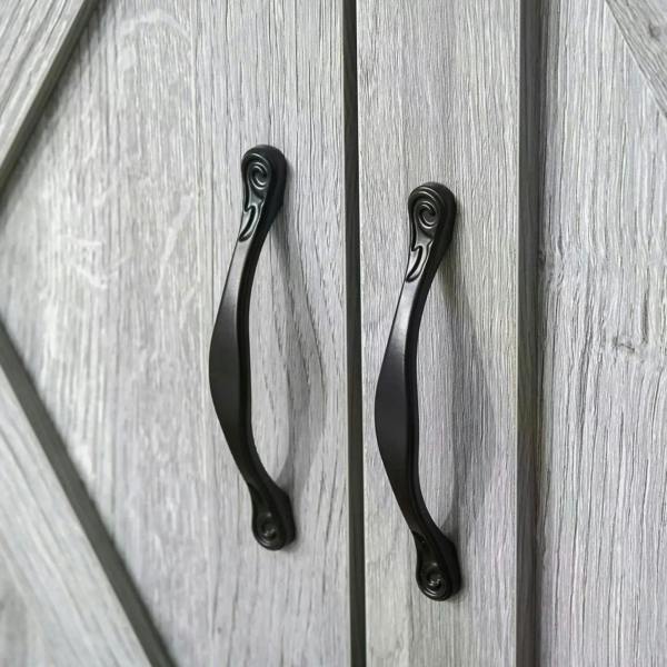 Black curved handles on grey crossbuck barn doors