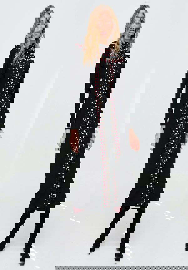 Woman wearing a black dress with red and white pattern on a white background