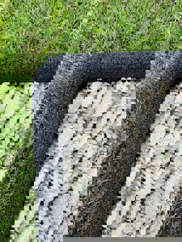 Black Flexiborder in a garden edging the lawn and stones