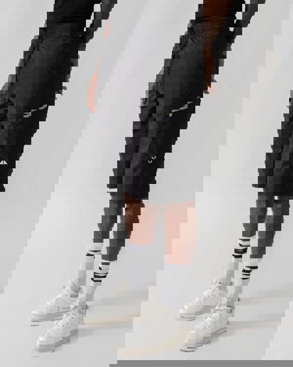 Model wearing Moose Knuckles Topflight Mens Cargo Shorts in Black 292 - side view