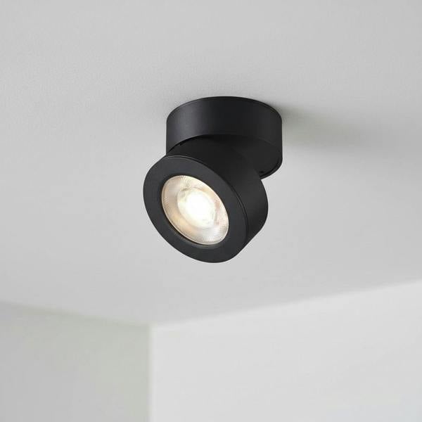 black adjustable ceiling lamp installed on a white ceiling in a house