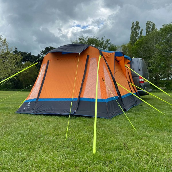 an orange Loopo Breeze® v2 Inflatable Campervan Awning by OLPRO on an empty campsite imageset:Orange