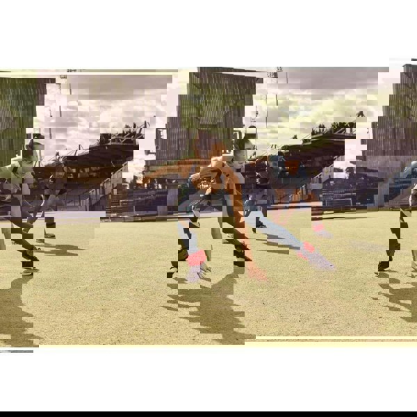 Man and woman working out on a field wearing Reebok Flexlock Ankle Weights 0.5kg