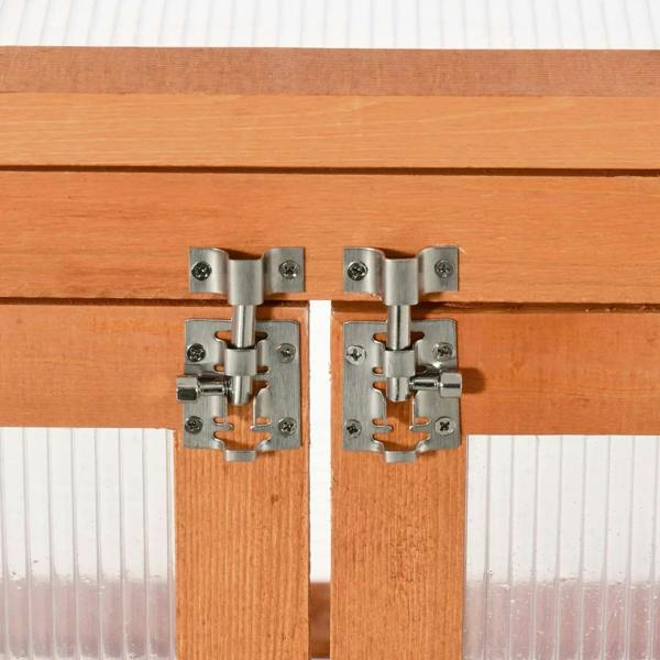 Metal latch hardware on a wood greenhouse cold frame door frame