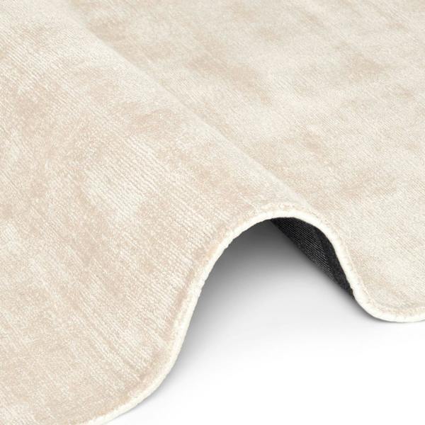 Close-up of a beige textured rug corner on a white background