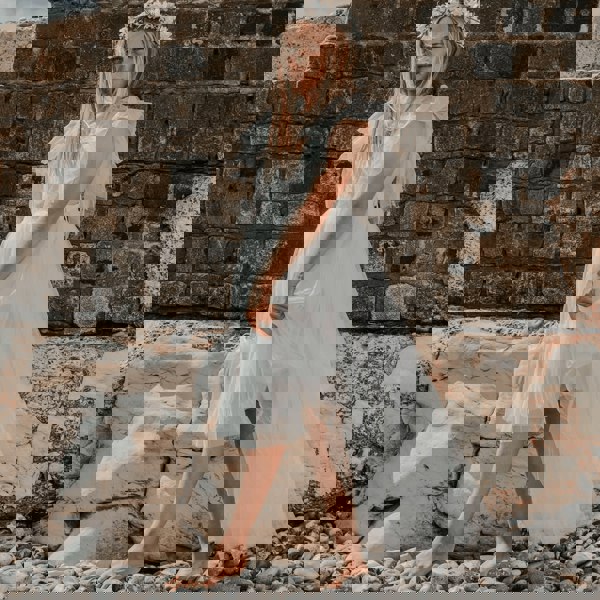 young girl walking on pebbled beach