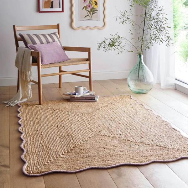 Woven jute rug on a wooden floor with a chair and decorative items.