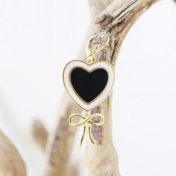 Gold vermeil heart earring with obsidian and mother of pearl on a branch.