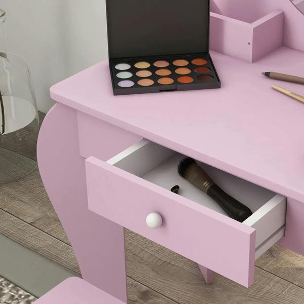 Pink kids vanity table drawer pulled open, showing storage inside