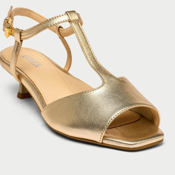 Gold sandal with open toe and T-strap on a light gray background