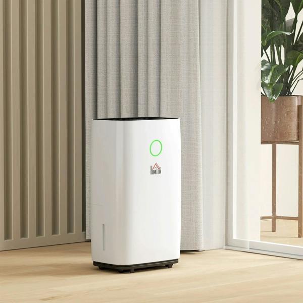 White portable dehumidifier standing on floor with green LED indicator light
