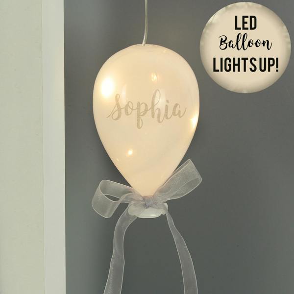 An illuminated frosted white glass balloon decoration with a grey ribbon and the name Sophia.