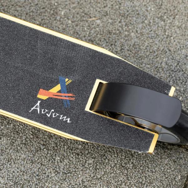 Black rear wheel and fender on a gold deck stunt scooter with textured surface