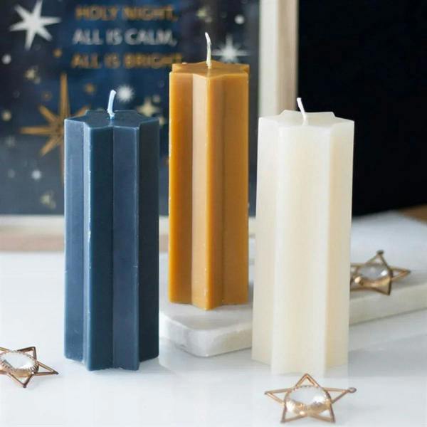 Star-shaped taper candles in cream, blue, and gold with wicks on display