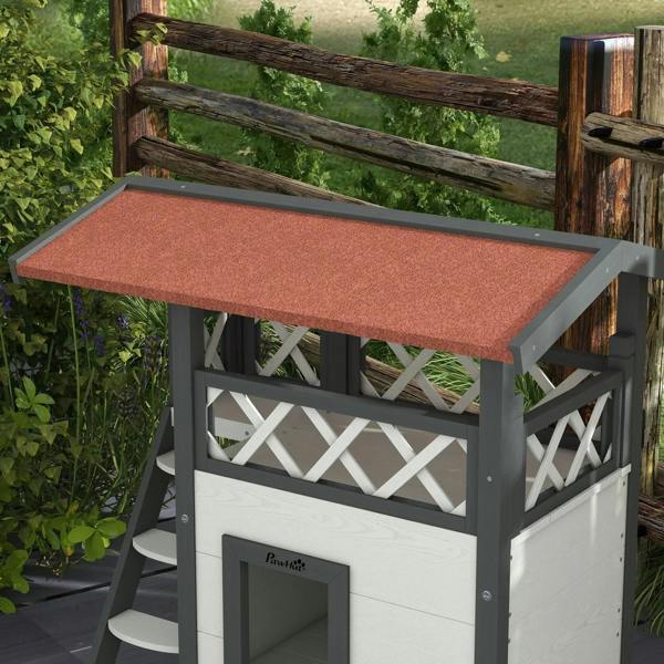 White cat house with balcony roof and front door cutout, ladder on the side