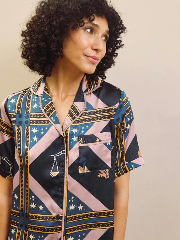 Woman wearing a patterned pyjama shirt with a neutral background