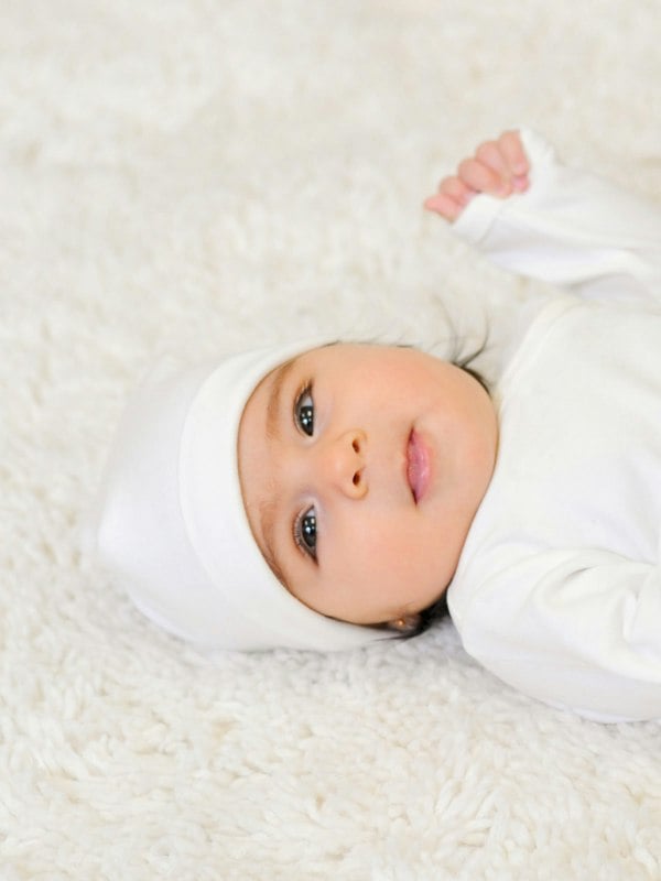 A Baby wearing Prima Cotton’s Organic Baby Hat for Sensitive Skin made from 100% GOTS-certified organic Egyptian cotton.