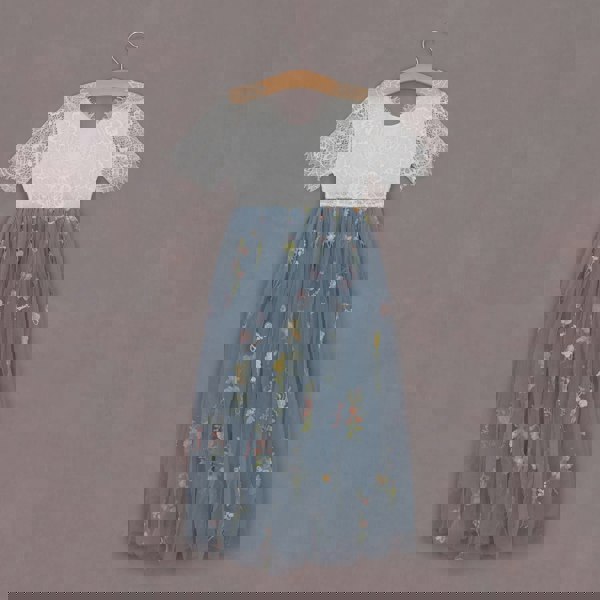 Two-tone dress with lace top and floral skirt on a hanger against a purple background