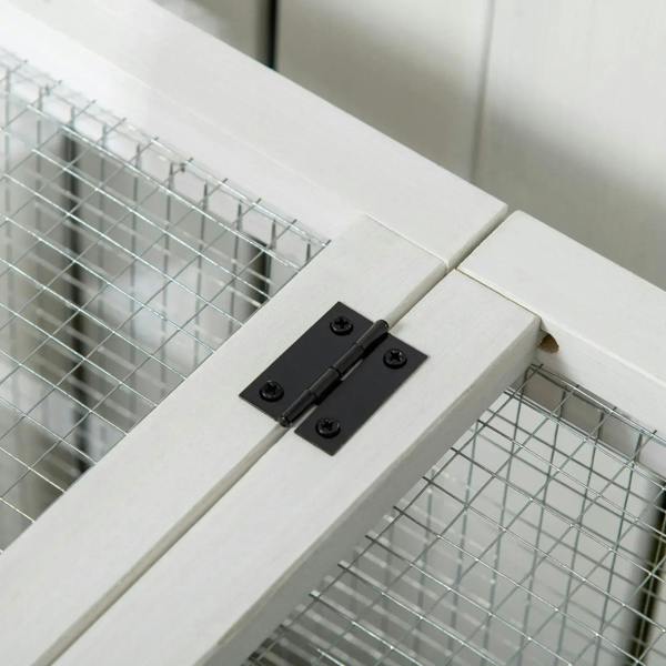 Close-up of latch hardware on wooden rabbit hutch frame connecting wire panels