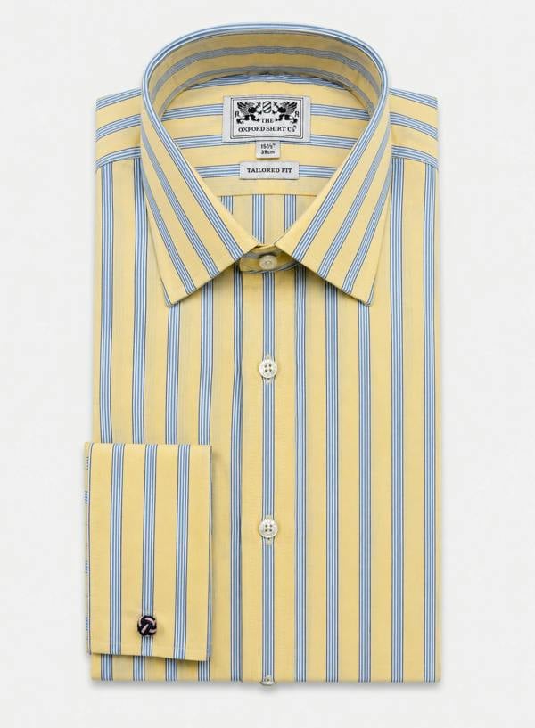 A folded men's dress shirt by featuring a pale yellow base with vertical light blue stripes, a pointed collar, and a buttoned front.