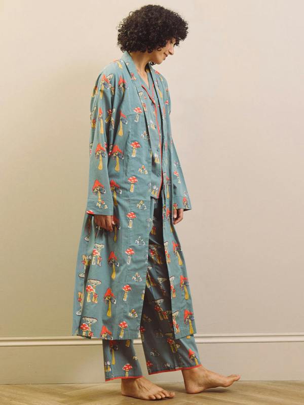 Person wearing a mushroom patterned robe and pyjama set against a plain background