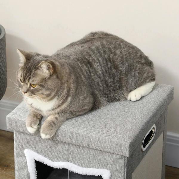 Grey tabby cat lounging on top cushion of a grey fabric cat cube house bed