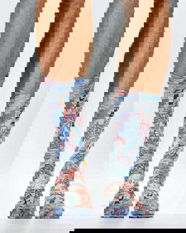 Colorful travel-themed socks worn by a person on a white background