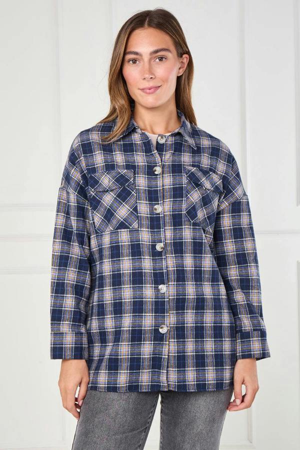 Woman wearing a blue plaid shirt against a white background