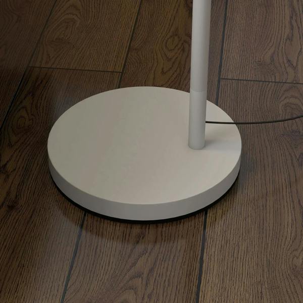 Round white base of floor lamp with power cord on wood flooring