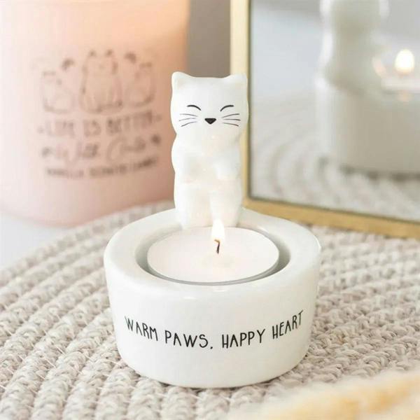 White cat-shaped tealight holder with round cavity and “WARM PAWS, HAPPY HEART” text