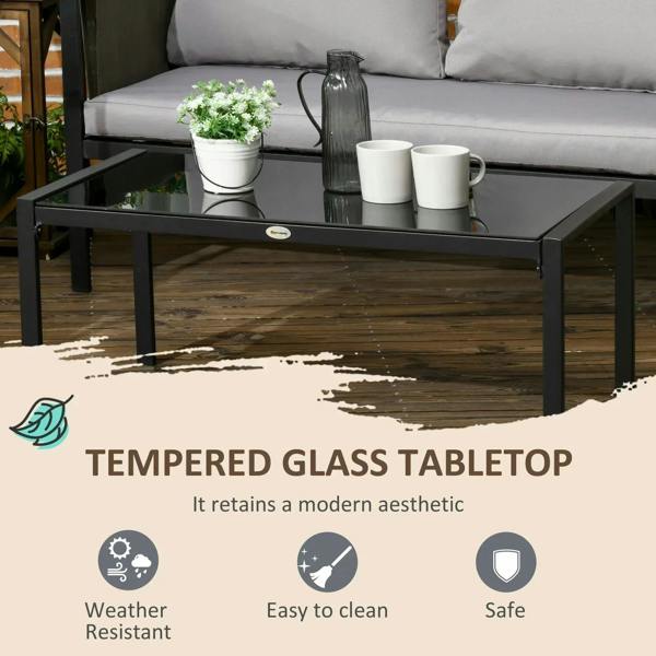 Tempered glass coffee table with black metal frame and light grey cushioned seating behind